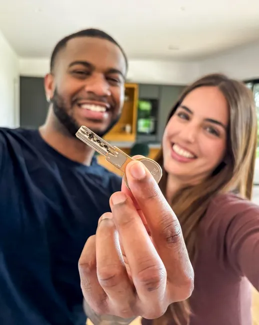 Casal comemorando com a chave do novo imóvel